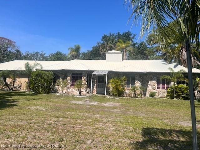 12115 S US Highway 41, Gibsonton, FL 33534 - ranch-style house featuring a front lawn, stone siding, and a chimney
