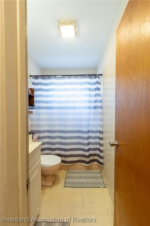full bathroom featuring tile patterned floors, vanity, a shower with shower curtain, and toilet