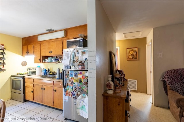 kitchen with light countertops, freestanding refrigerator, electric stove, and visible vents