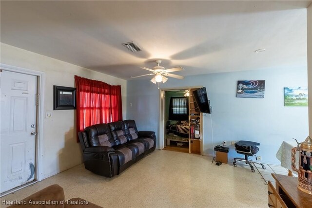 living area featuring visible vents and a ceiling fan