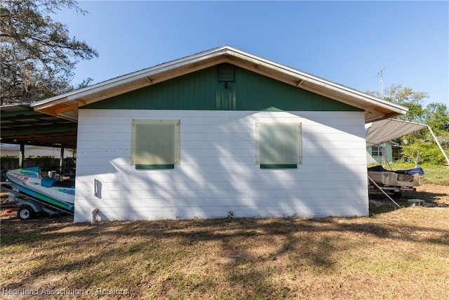 view of property exterior with a yard and a carport