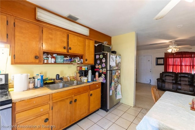 kitchen featuring a ceiling fan, a sink, stainless steel appliances, light countertops, and visible vents