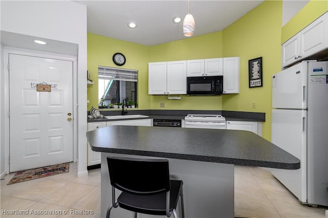 kitchen featuring a kitchen bar, white appliances, a kitchen island, and sink