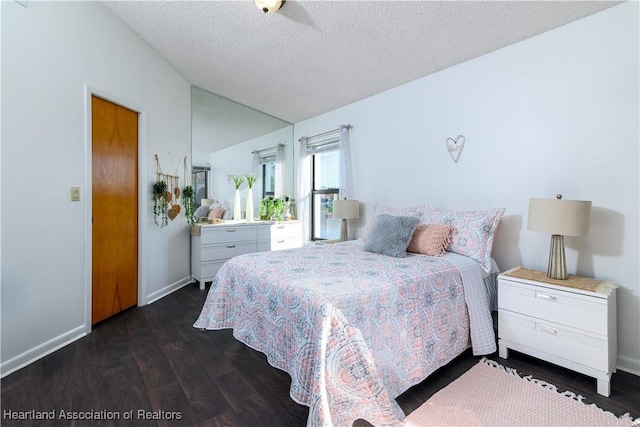 bedroom with ceiling fan, a textured ceiling, and dark wood-type flooring