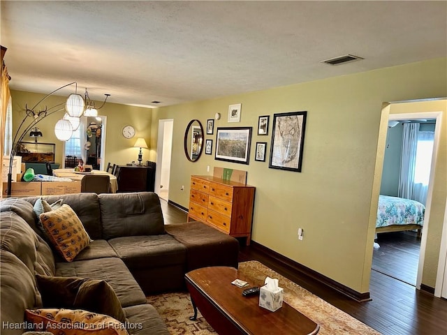 living room featuring an inviting chandelier and dark hardwood / wood-style floors