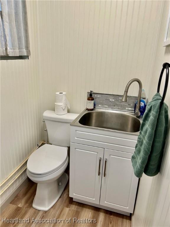 bathroom featuring toilet, vanity, and hardwood / wood-style floors