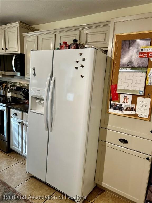 kitchen featuring stainless steel appliances, backsplash, and light tile patterned floors