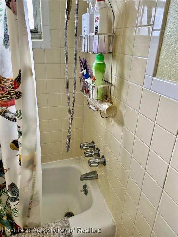 bathroom with shower / bathtub combination with curtain