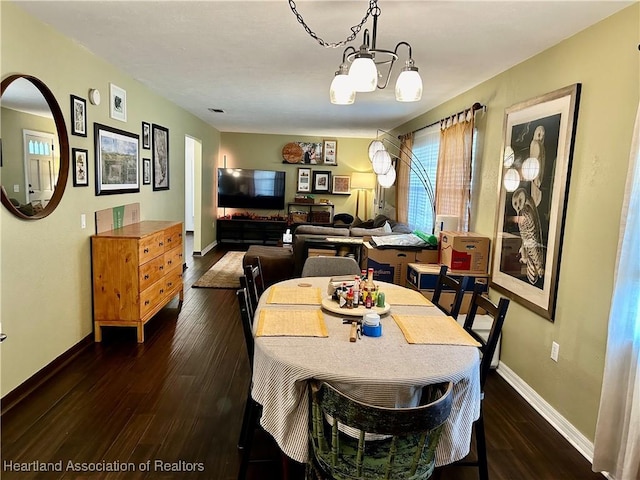 dining area featuring a notable chandelier and dark hardwood / wood-style floors