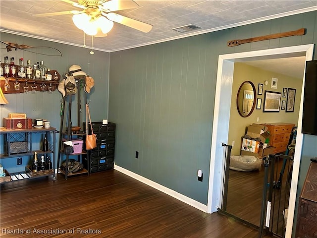 interior space featuring dark wood-type flooring, ceiling fan, and ornamental molding