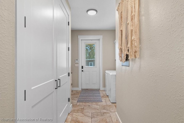 doorway to outside with washer and clothes dryer