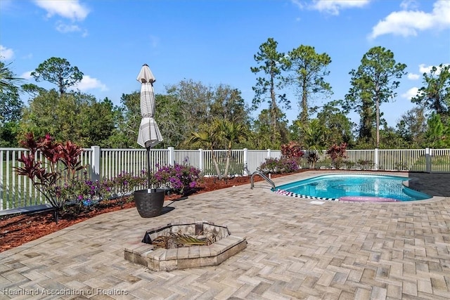 view of swimming pool featuring an outdoor fire pit and a patio area