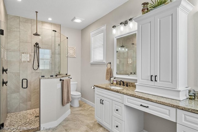 bathroom with vanity, toilet, and a shower with shower door