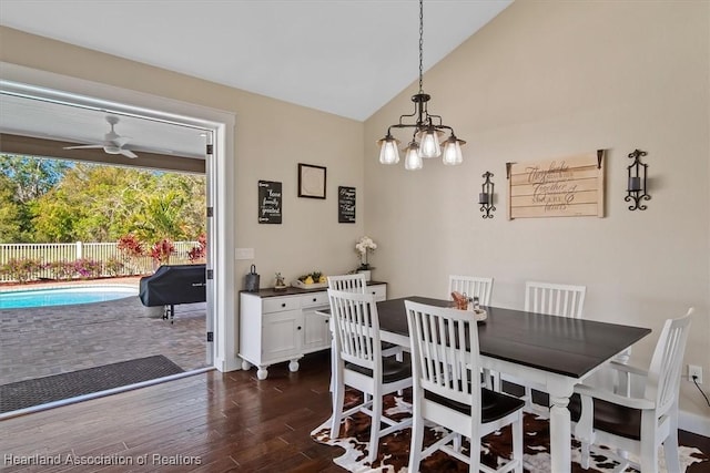 dining space with lofted ceiling, dark hardwood / wood-style floors, and ceiling fan with notable chandelier