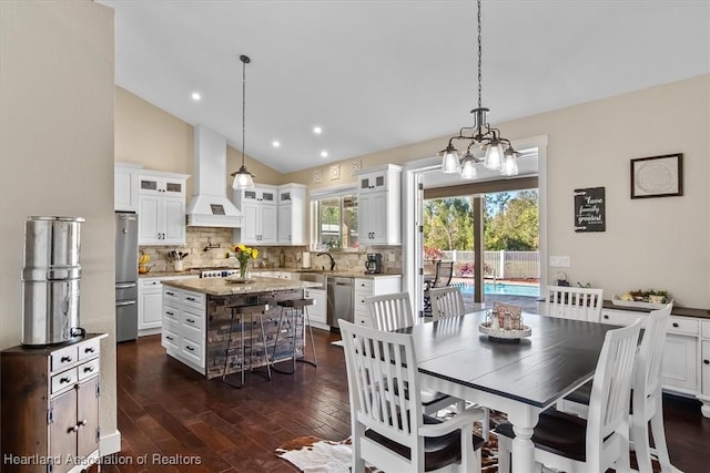 dining area with high vaulted ceiling, a chandelier, and dark hardwood / wood-style flooring