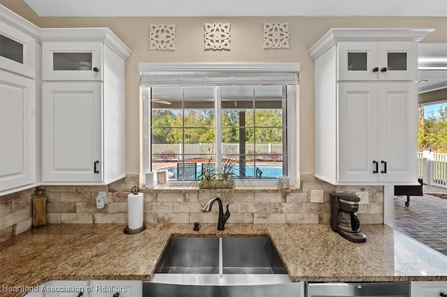 kitchen featuring white cabinetry, sink, and tasteful backsplash