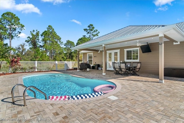 view of pool with french doors, area for grilling, ceiling fan, and a patio area