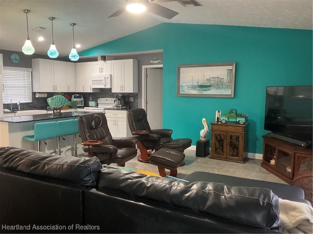 living room with ceiling fan and vaulted ceiling