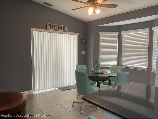 dining space featuring ceiling fan, plenty of natural light, light tile patterned floors, and lofted ceiling