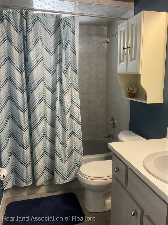 full bathroom featuring toilet, vanity, and shower / tub combo with curtain