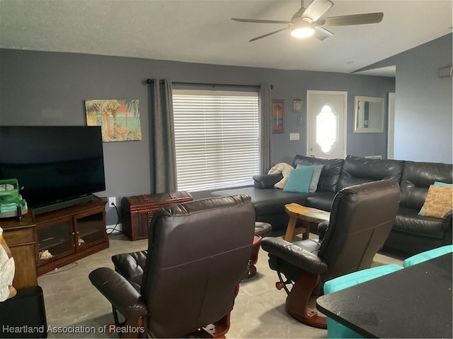 living room featuring a textured ceiling, ceiling fan, and vaulted ceiling