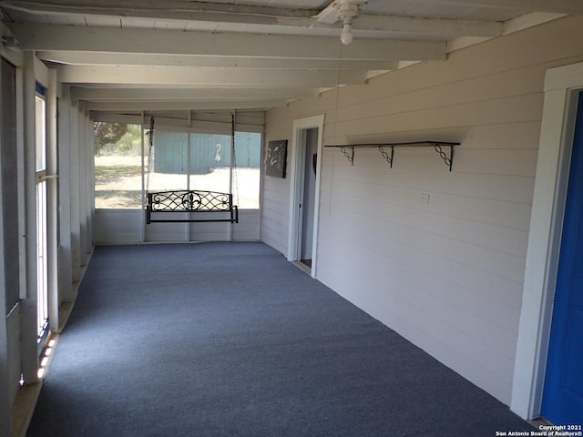 unfurnished sunroom with beamed ceiling