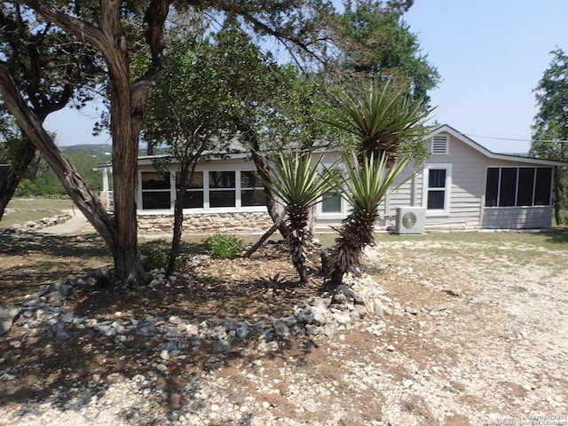 exterior space with a sunroom and central AC unit