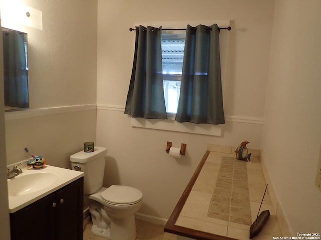 bathroom featuring toilet, tile flooring, and vanity