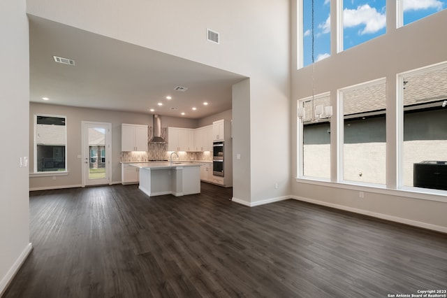 unfurnished living room with dark hardwood / wood-style floors, a healthy amount of sunlight, and sink