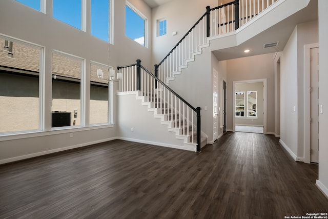 entrance foyer with a towering ceiling and dark hardwood / wood-style floors