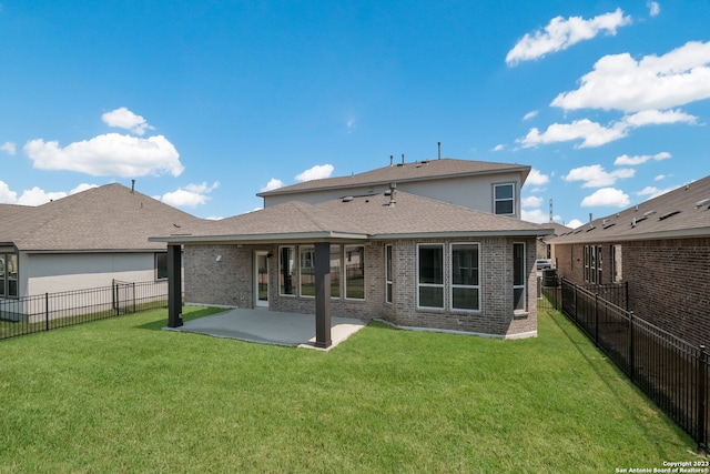 back of house featuring a lawn and a patio