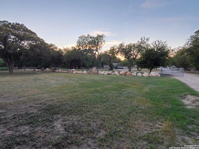 yard at dusk featuring a rural view