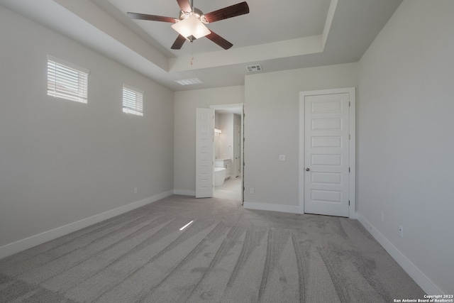 unfurnished bedroom featuring carpet flooring, a closet, ceiling fan, and a tray ceiling