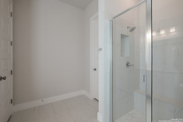 bathroom with a shower with shower door and tile flooring