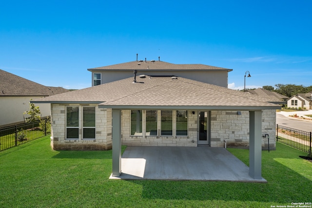 back of house with a patio area and a yard