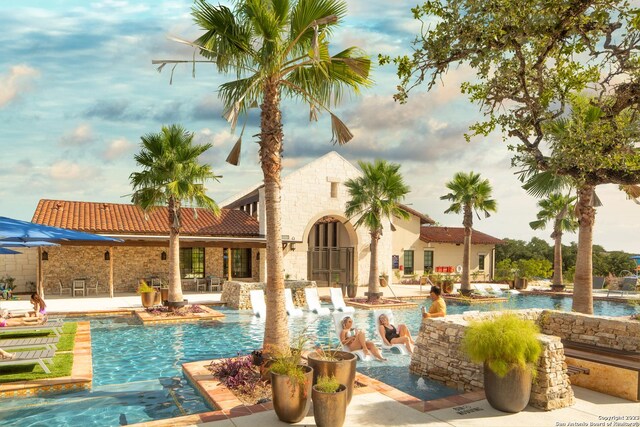 view of pool with a patio area and pool water feature