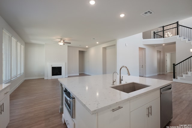 kitchen featuring stainless steel appliances, sink, ceiling fan, and hardwood / wood-style flooring