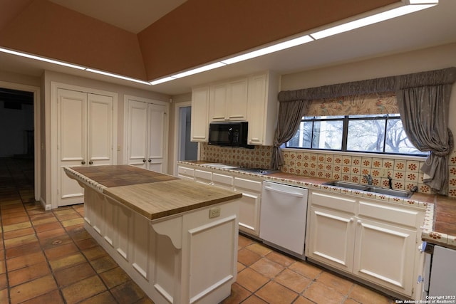 kitchen featuring tasteful backsplash, white cabinets, dishwasher, and a center island