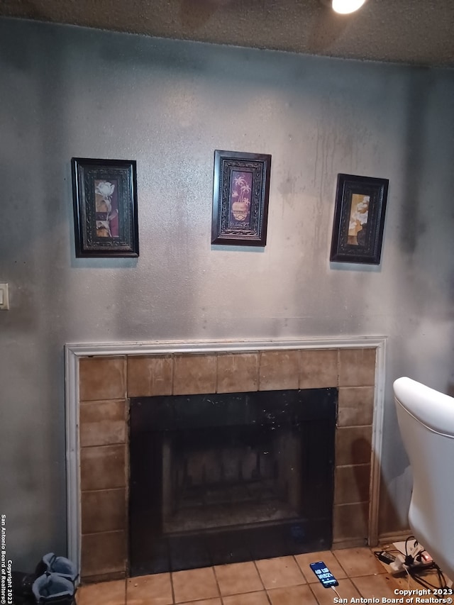 room details featuring light tile floors, toilet, and a fireplace