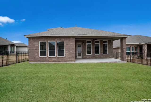 rear view of property featuring a patio and a lawn