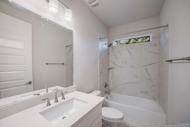 full bathroom with tiled shower / bath, toilet, and vanity