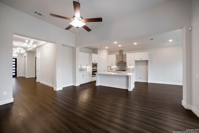 unfurnished living room with dark hardwood / wood-style floors, ceiling fan with notable chandelier, and sink