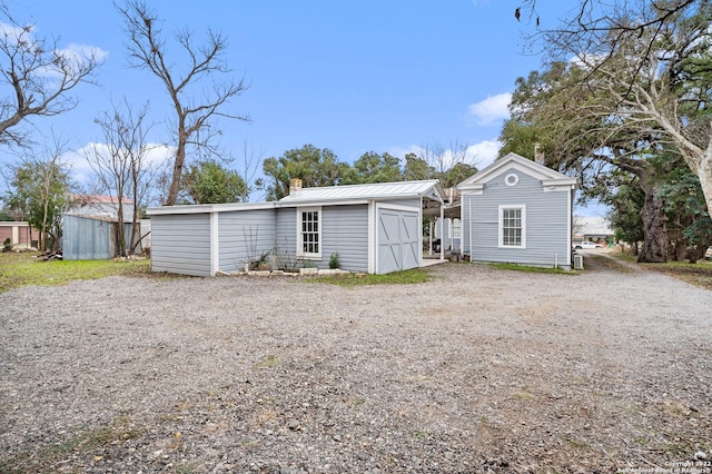 rear view of house with an outdoor structure