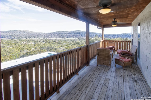 wooden terrace with a mountain view and ceiling fan