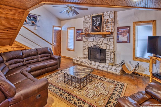 living room featuring ceiling fan, a stone fireplace, wood ceiling, and vaulted ceiling