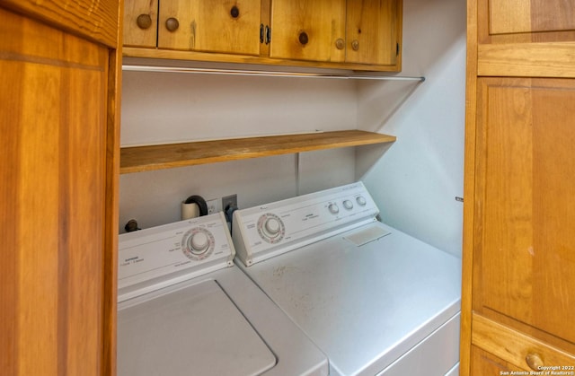 washroom featuring washing machine and dryer and cabinets