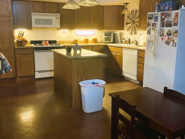 kitchen featuring decorative light fixtures, a center island, white appliances, and sink