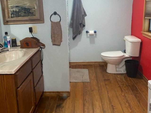 bathroom featuring toilet, hardwood / wood-style floors, and vanity