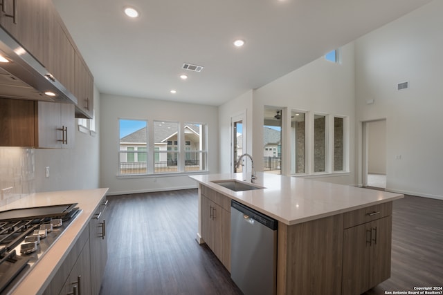 kitchen with a kitchen island with sink, stainless steel appliances, sink, and dark hardwood / wood-style flooring