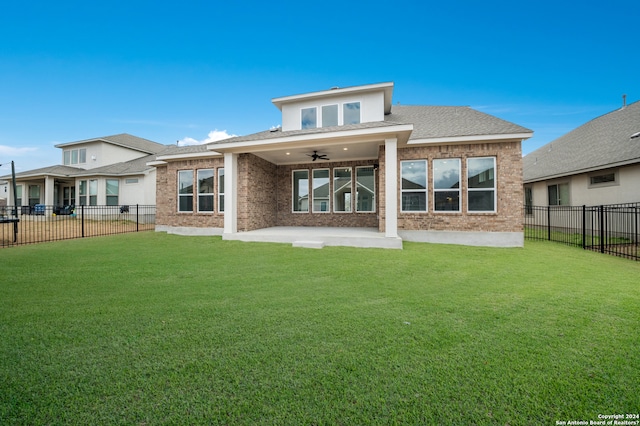 rear view of property featuring a yard, a patio area, and ceiling fan